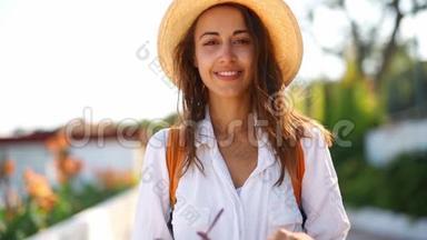 穿着白色衬衫和草色太阳帽的迷人女游客戴着太阳镜